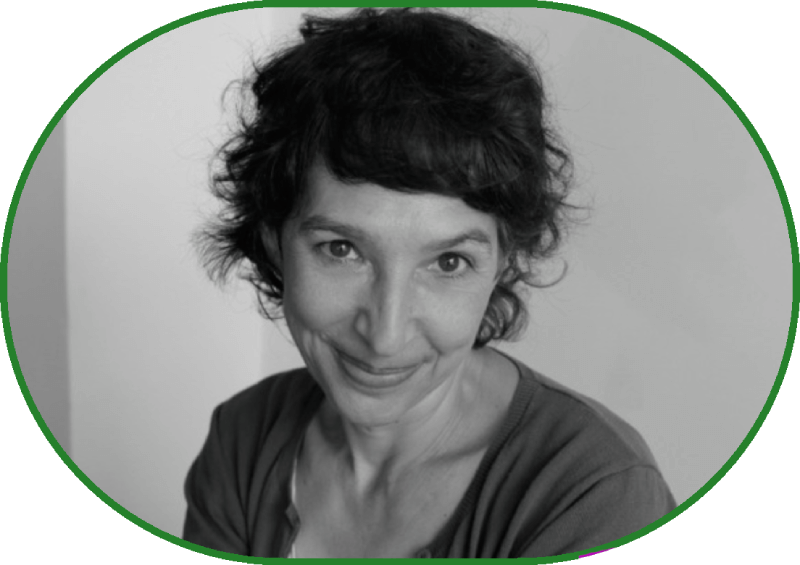 Великий план, чорно-білий портрет. На тлі світлої стіни — жінка з недовгим кучерявим волоссям пильно дивиться з-під лоба в кадр і стримано всміхається.